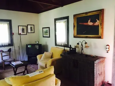 a living room with a couch and a tv at Moinho do Comandante in Faial