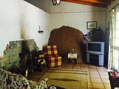 a living room with a fireplace and a tv at Moinho do Comandante in Faial