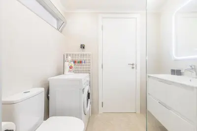a white bathroom with a toilet and a sink at Costa Apartment II - Linda Vista in Caniço