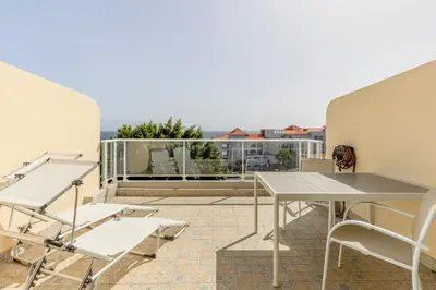 a balcony with a table and chairs on a building at Costa Apartment II - Linda Vista in Caniço