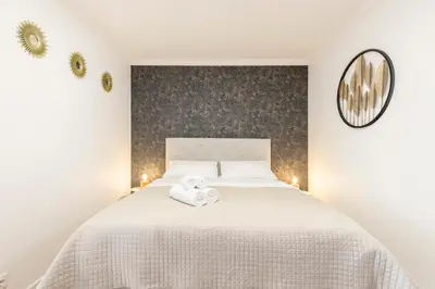 a bedroom with a white bed with two towels on it at Costa Apartment II - Linda Vista in Caniço