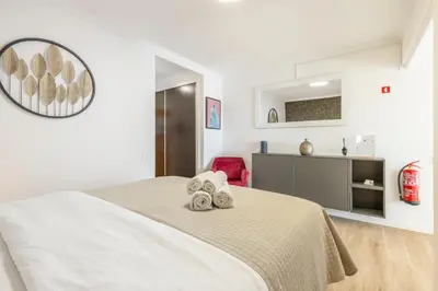 a white bedroom with a bed with towels on it at Costa Apartment II - Linda Vista in Caniço