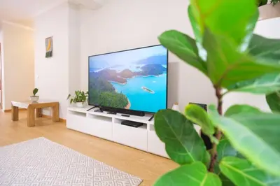 a living room with a flat screen tv on a cabinet at Brava Home - Best Location to Explore Madeira in Ribeira Brava