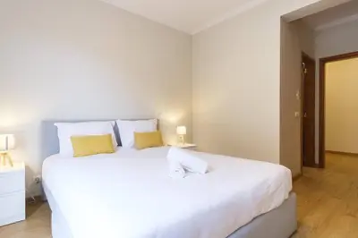 a bedroom with a large white bed with yellow pillows at Brava Home - Best Location to Explore Madeira in Ribeira Brava