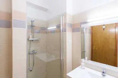 a bathroom with a shower and a sink and a mirror at Brava Home - Best Location to Explore Madeira in Ribeira Brava