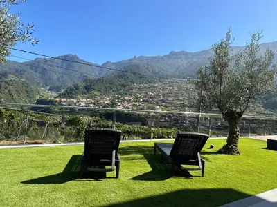 two chairs sitting in the grass with a view of a city at Villa Montana in São Vicente