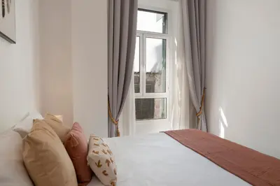 a bedroom with a bed with pillows and a window at Apartamento do Carmo by An Island Apart in Funchal
