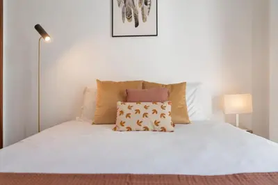 a white bed with a pillow on top of it at Apartamento do Carmo by An Island Apart in Funchal