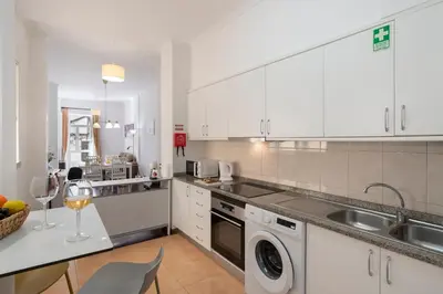 a kitchen with white cabinets and a sink and a dishwasher at Apartamento do Carmo by An Island Apart in Funchal