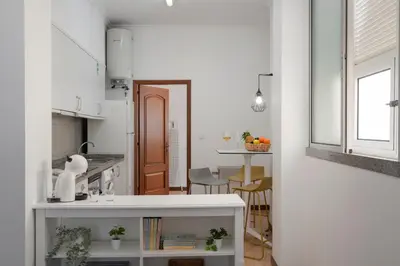 a kitchen with a white counter and a table at Apartamento do Carmo by An Island Apart in Funchal