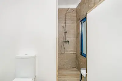 a bathroom with a shower and a toilet at Chalé Henrique - Beachfront apartments at Calheta Beach in Calheta