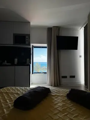 a bedroom with a bed with a view of the ocean at Chalé Henrique - Beachfront apartments at Calheta Beach in Calheta