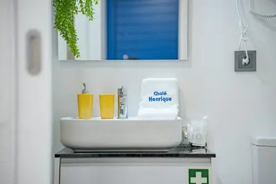 a bathroom with a sink and a mirror at Chalé Henrique - Beachfront apartments at Calheta Beach in Calheta