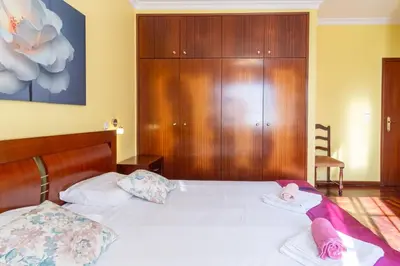 a bedroom with a bed with white sheets and pink pillows at GuestReady - Peaceful Paradise in Madeira in Arco da Calheta