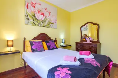 a bedroom with a bed with pink and purple pillows at GuestReady - Peaceful Paradise in Madeira in Arco da Calheta