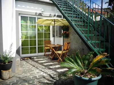 a patio with a table and an umbrella at Madeira Holiday Flats in Funchal
