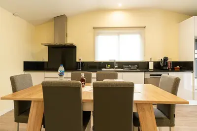 a kitchen with a wooden table and chairs at Florenças House - Private Jacuzzi & Garden in Calheta