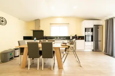 a kitchen and dining room with a wooden table and chairs at Florenças House - Private Jacuzzi & Garden in Calheta