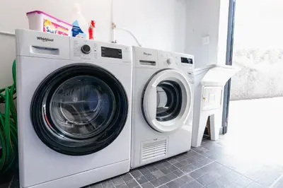a washing machine and a dryer in a room at Florenças House - Private Jacuzzi & Garden in Calheta