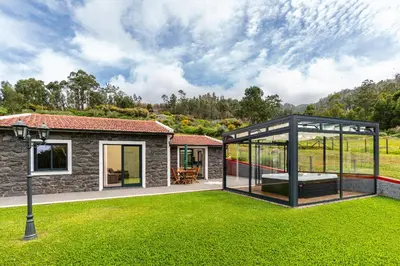 a glass extension of a house with a garden at Florenças House - Private Jacuzzi & Garden in Calheta
