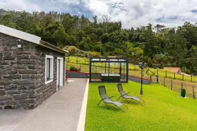 a garden with two chairs and a gazebo at Florenças House - Private Jacuzzi & Garden in Calheta