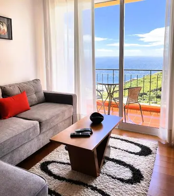 a living room with a couch and a coffee table at Vista Reis Magos in Caniço