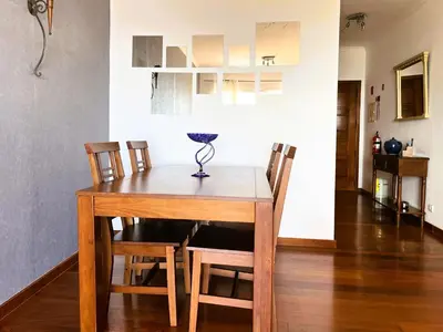 a dining room table and chairs in a room at Vista Reis Magos in Caniço
