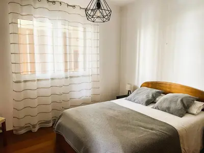 a bedroom with a large bed with a window at Vista Reis Magos in Caniço