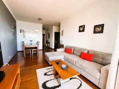 a living room with a couch and a table at Vista Reis Magos in Caniço