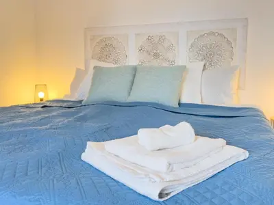 a blue bed with towels on top of it at Calheta Bay View House - Family and Group Residence in Arco da Calheta