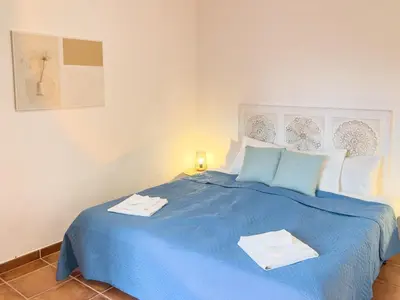 a blue bed with two towels on top of it at Calheta Bay View House - Family and Group Residence in Arco da Calheta