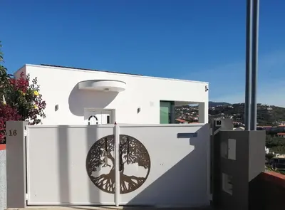a white building with a tree on the side of it at The Tree of Life House in Ponta do Sol