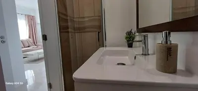 a white bathroom with a sink and a mirror at The Tree of Life House in Ponta do Sol