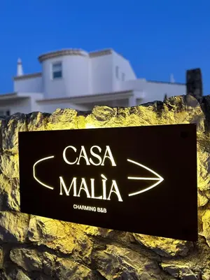 a sign for aalling bar on a stone wall at Casa Malìa Luxury Guest House in Luz