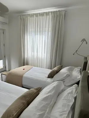a bedroom with two beds and a window at Casa Malìa Luxury Guest House in Luz