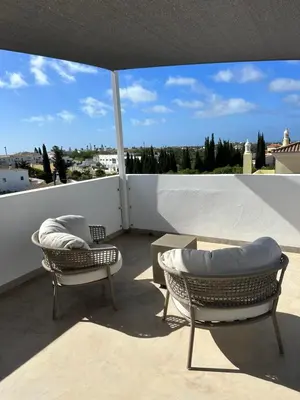 a patio with two chairs and a table on a balcony at Casa Malìa Luxury Guest House in Luz