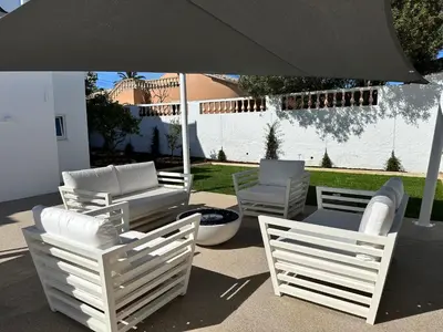 a group of chairs and an umbrella on a patio at Casa Malìa Luxury Guest House in Luz