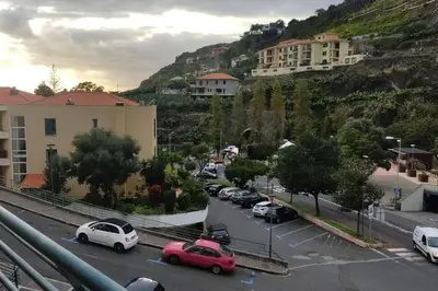 a city with cars parked in a parking lot at Comfy apt in the heart of Ponta do Sol in Ponta do Sol