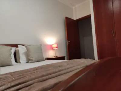 a bedroom with a bed and a lamp on a table at Sol e Mar in Ponta do Sol