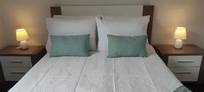 a bedroom with a bed with two lamps on tables at Sol e Mar in Ponta do Sol