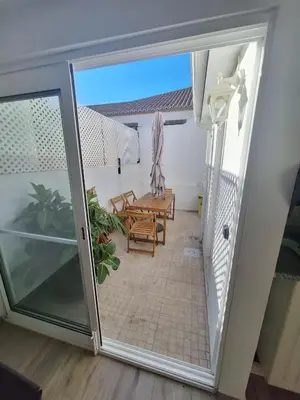 a sliding glass door leading to a patio with a table and chairs at Happy Stay Funchal in Funchal