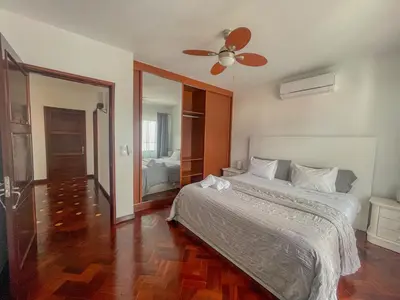 a bedroom with a bed and a ceiling fan at Villa Supranee Ocean View in Câmara de Lobos