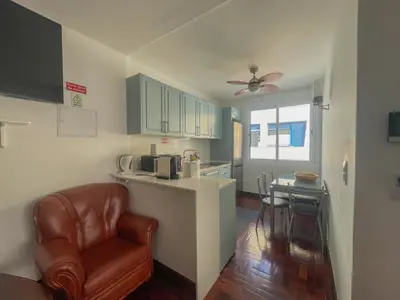 a kitchen with a counter and a chair and a table at Villa Supranee Ocean View in Câmara de Lobos