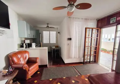 a living room with a couch and a ceiling fan at Villa Supranee Ocean View in Câmara de Lobos