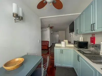 a kitchen with a table with a wooden bowl on it at Villa Supranee Ocean View in Câmara de Lobos