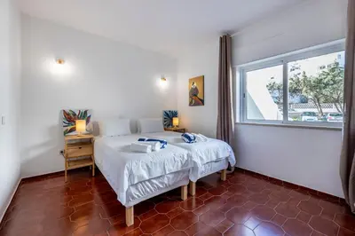a bedroom with a bed and a window at Casa Jóia in Luz