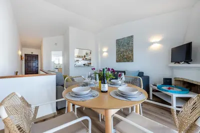 a dining room and living room with a table and chairs at Casa Jóia in Luz