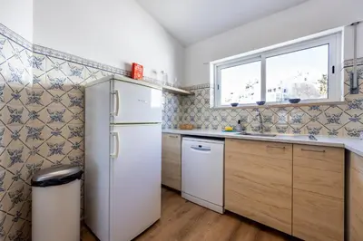 a kitchen with a refrigerator and a window at Casa Jóia in Luz