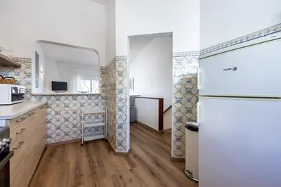 a kitchen with a white refrigerator in a room at Casa Jóia in Luz