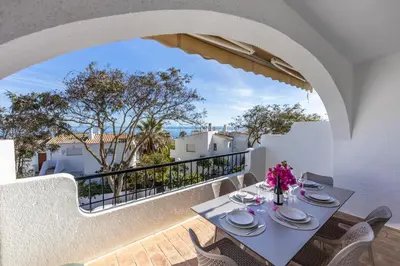 a dining room with a table and chairs on a balcony at Casa Jóia in Luz